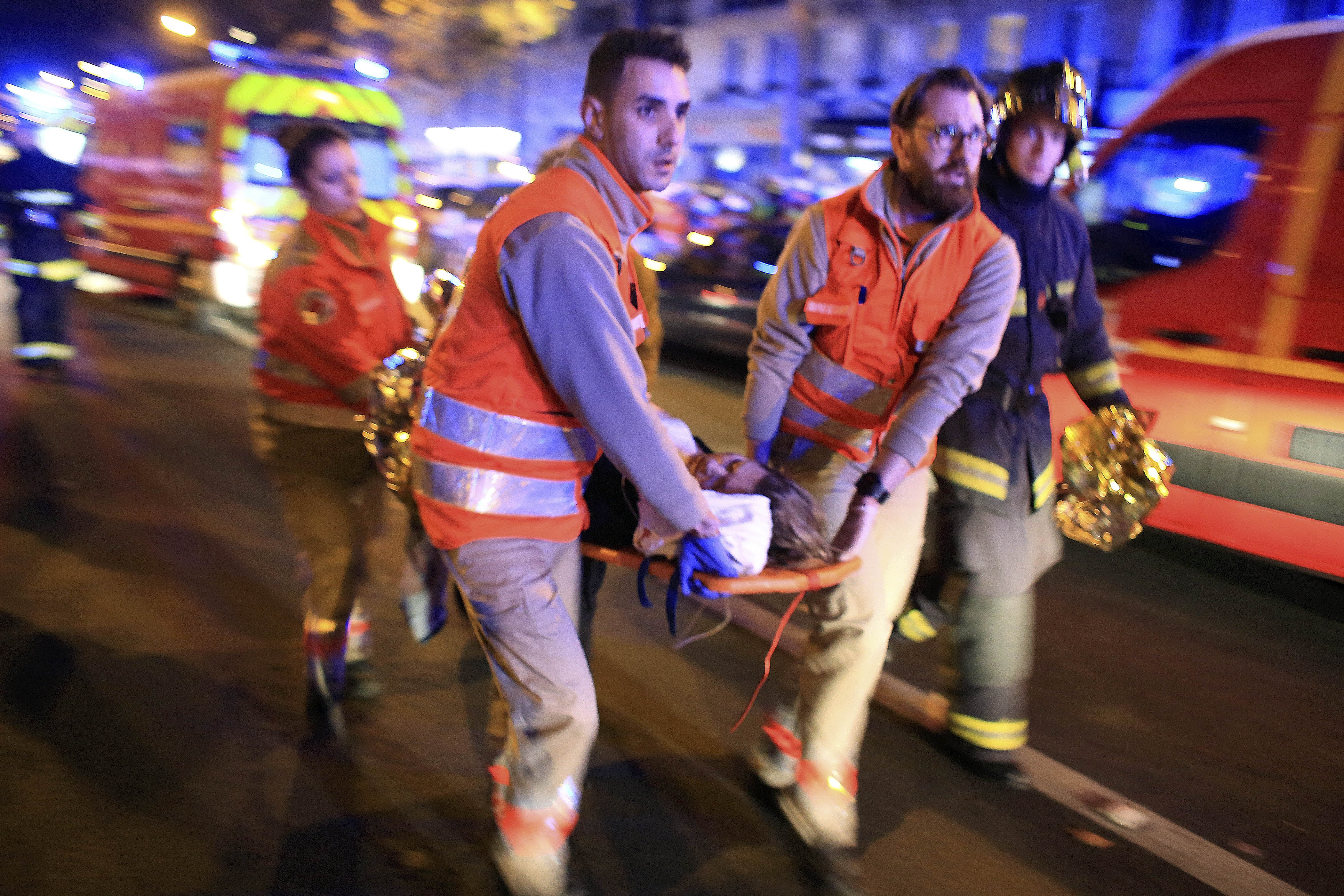 FILE - In this Nov. 13, 2015, file photo, a woman is being evacuated from the Bataclan concert hall after a shooting in Paris. In a poll conducted by the Associated Press and the Times Square Alliance, 64 percent of those polled believe the attacks on Charlie Hebdo and the Jewish market, then the Bataclan concert hall and other city sites, were among the very or extremely important news events of 2015. (AP Photo/Thibault Camus, File)